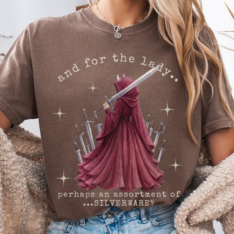 Brown t-shirt with "and for the lady. perhaps an assortment of ... silverware?" text and a hooded figure holding a sword.