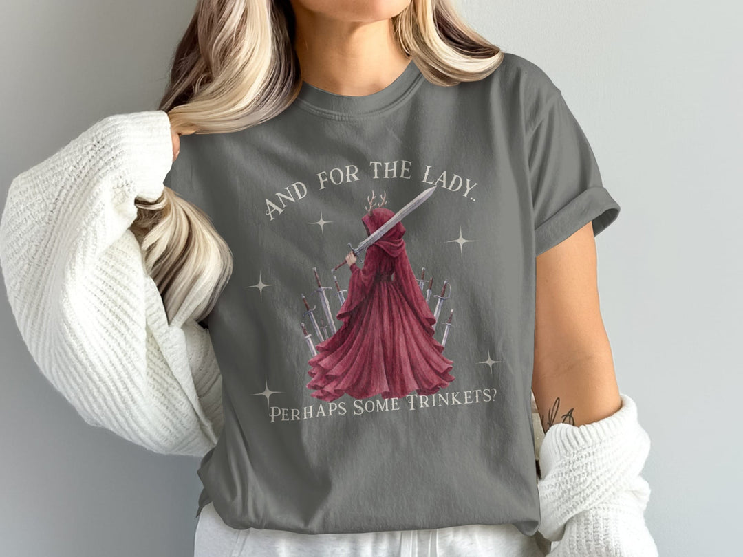 Woman wearing grey t-shirt with red cloak figure holding sword and text.