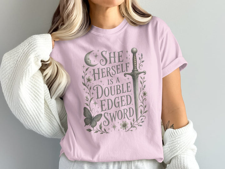 Pink t-shirt with graphic "SHE HERSELF IS A DOUBLE EDGED SWORD" and sword illustration.