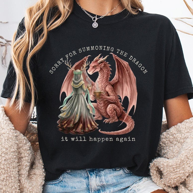 Black t-shirt with dragon and woman illustration and text "sorry for summoning the dragon it will happen again".
