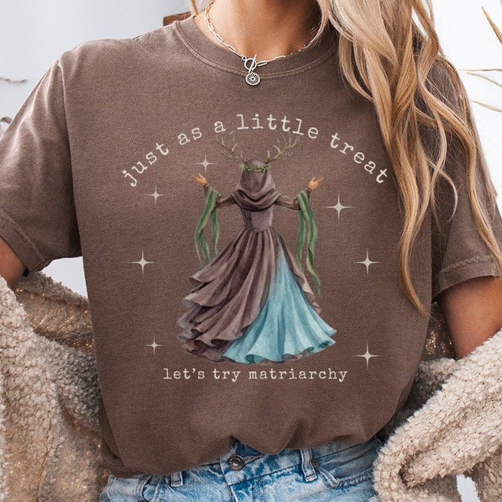 Brown t-shirt with "just as a little treat let's try matriarchy" text and fairy graphic.
