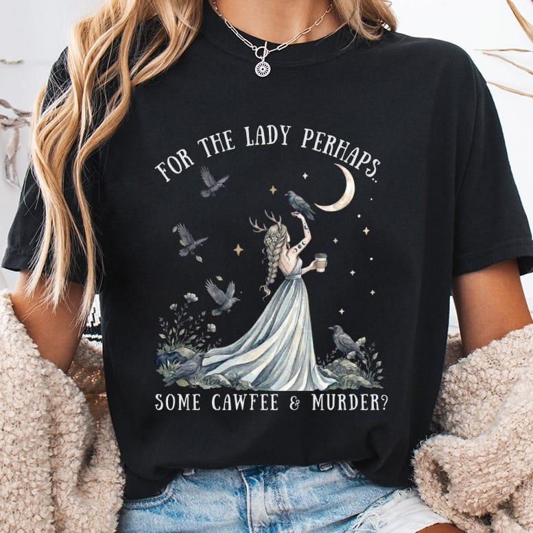 Black t-shirt featuring a fantasy graphic of a horned woman with crows, a crescent moon, and the text FOR THE LADY PERHAPS... SOME CAWFEE & MURDER?