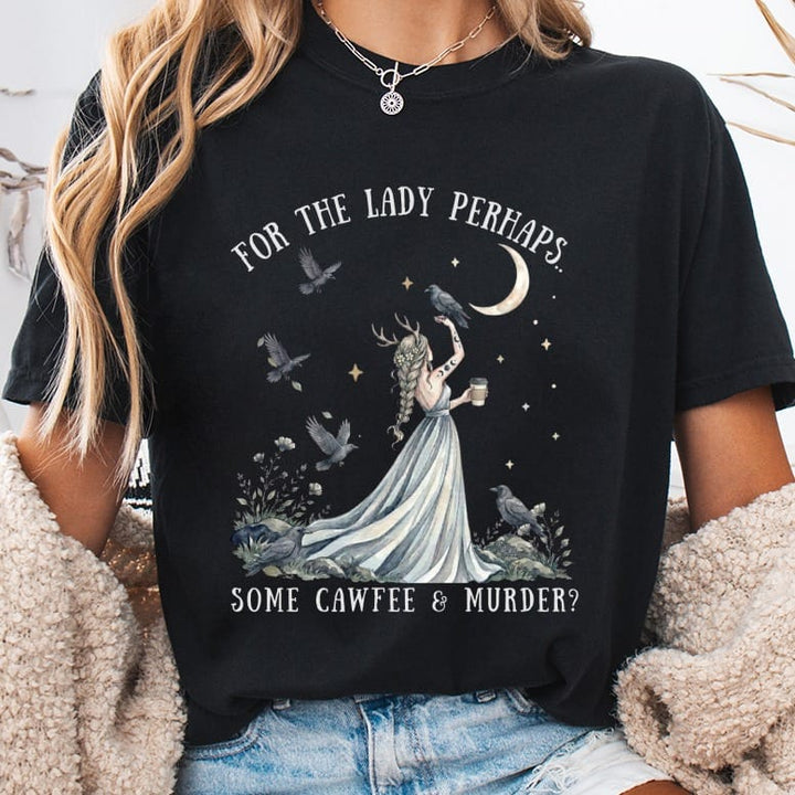 Black t-shirt featuring a fantasy graphic of a horned woman with crows, a crescent moon, and the text FOR THE LADY PERHAPS... SOME CAWFEE & MURDER?