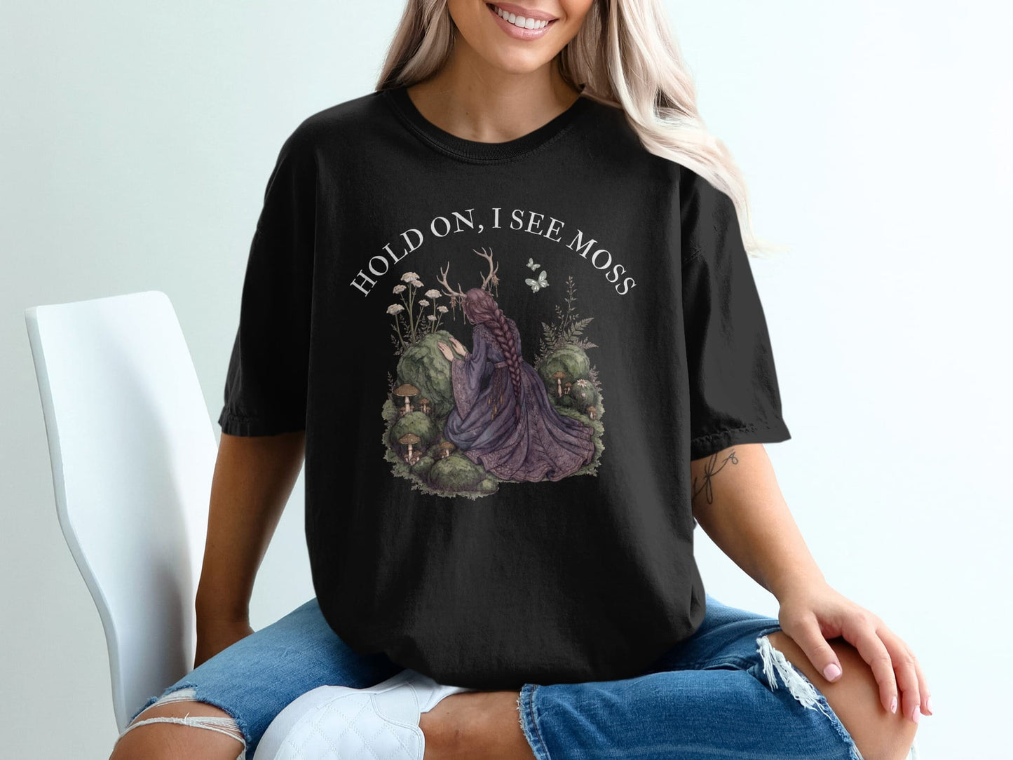Black t-shirt with "HOLD ON, I SEE MOSS" and forest scene graphic.