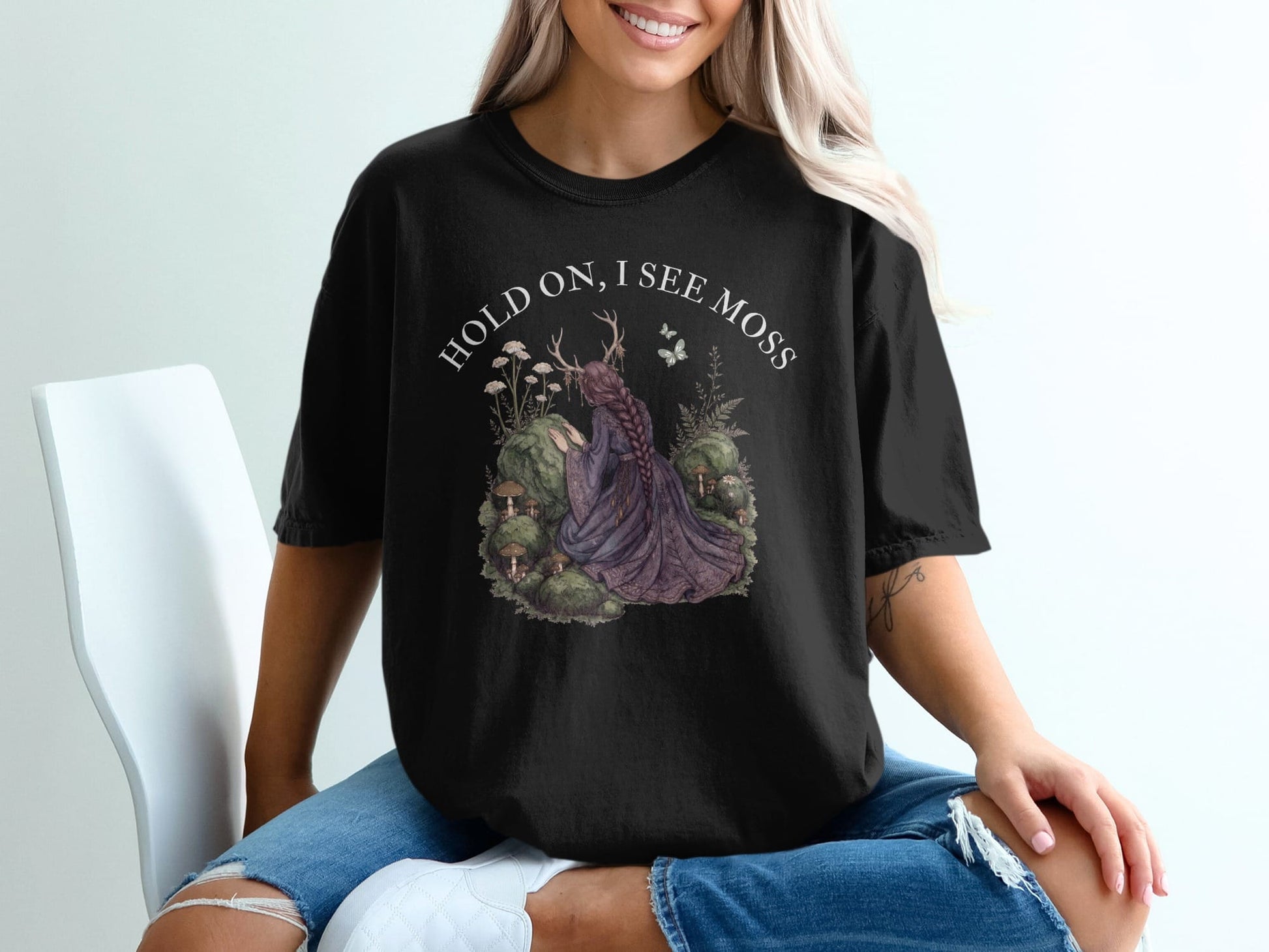 Black t-shirt with "HOLD ON, I SEE MOSS" and forest scene graphic.
