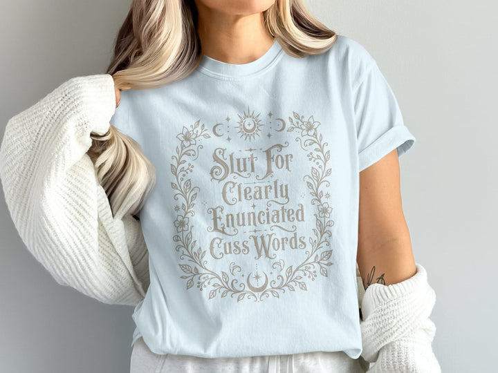 Light blue t-shirt with a floral wreath and text: "Slut For Clearly Enunciated Cuss Words."