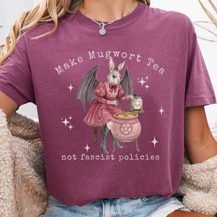 Rabbit in dress stirring cauldron with "Make Mugwort Tea, not fascist policies" text.