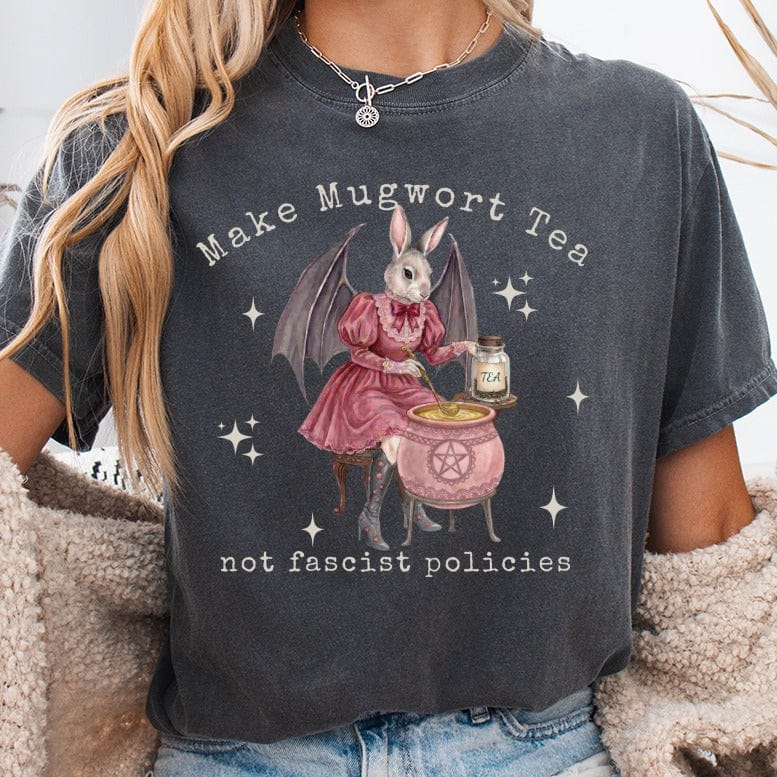T-shirt with a bat-winged bunny in a pink dress making tea in a cauldron.