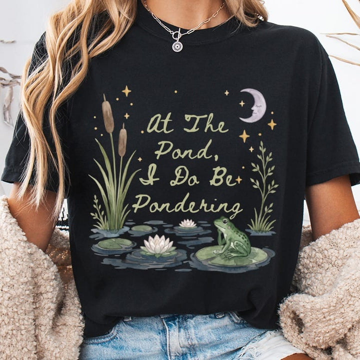Black t-shirt with a pond scene and text "At The Pond, I Do Be Pondering."