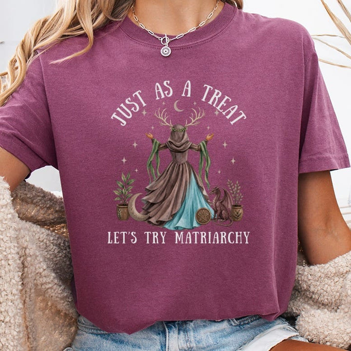 T-shirt with mystical matron, dragon, plants, moon, and text "JUST AS A TREAT LET'S TRY MATRIARCHY".