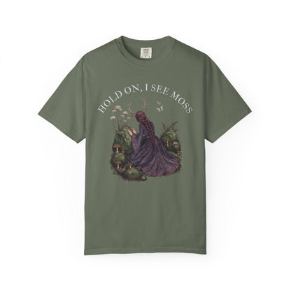 Woman in purple dress with moss and mushrooms, text "HOLD ON, I SEE MOSS".