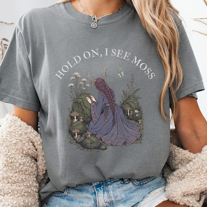 Gray t-shirt with "HOLD ON, I SEE MOSS" text and forest nymph illustration.
