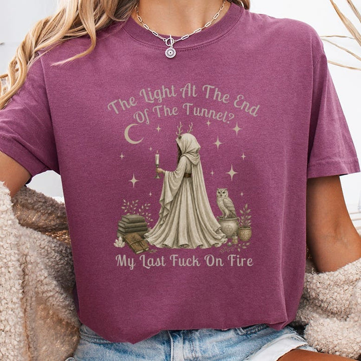 T-shirt with a mystical design of a cloaked figure, owl, and books.