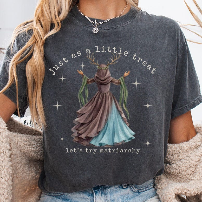 T-shirt with "just as a little treat, let's try matriarchy" and a mythical figure.