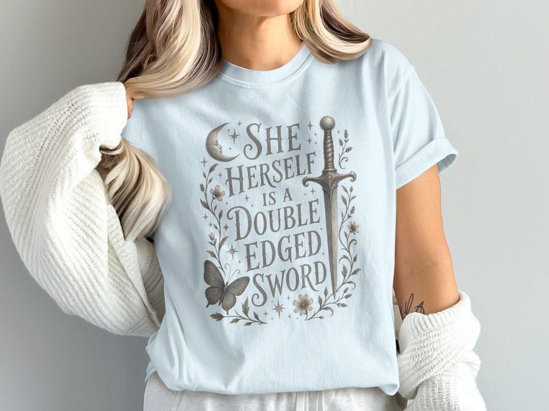 Light blue t-shirt with text "SHE HERSELF IS A DOUBLE EDGED SWORD" and illustration.