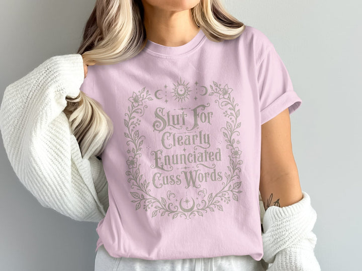 Pink t-shirt with "Slut For Clearly Enunciated Cuss Words" in a floral wreath.